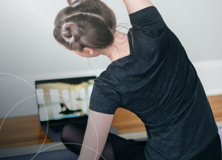 Woman attending virtual yoga class from home