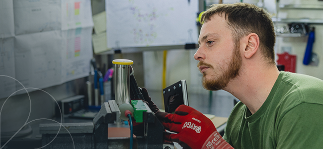 A photo of a man in a green shirt working on a project.